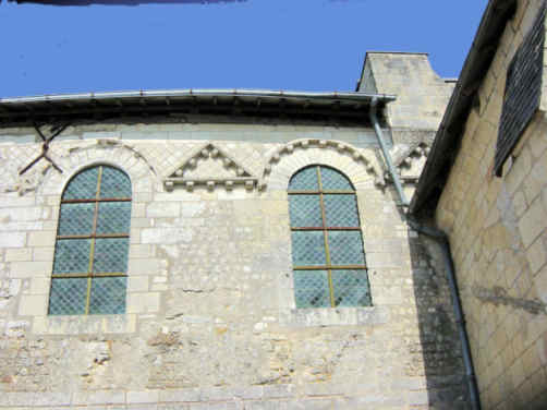 Entre les jambages des fenêtres, un triangle de petit appareil. L'arc de chaque fenêtre est décoré de chevrons sculptés de billettes. Entre les deux arcs, un triangle également décoré de chevrons à billettes