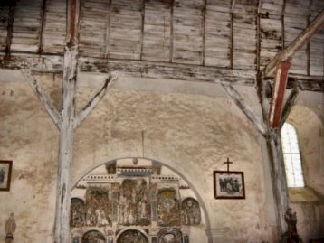 A gauche: mur sud de la nef: bas-relief (ancien retable) et piliers de bois