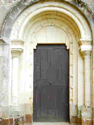 A gauche: porte donnant accès au bras sud du transept, décorée de boutons sculptés