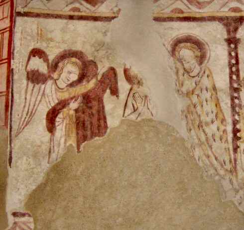 A gauche, un ange tient à deux mains la tunique rouge - au centre, le Christ dont les deux paumes sont tournées vers l'extérieur et dont les deux pouces se touchent. - à droite, Saint-Jean-Baptiste vêtu d'un manteau en peaux de bête